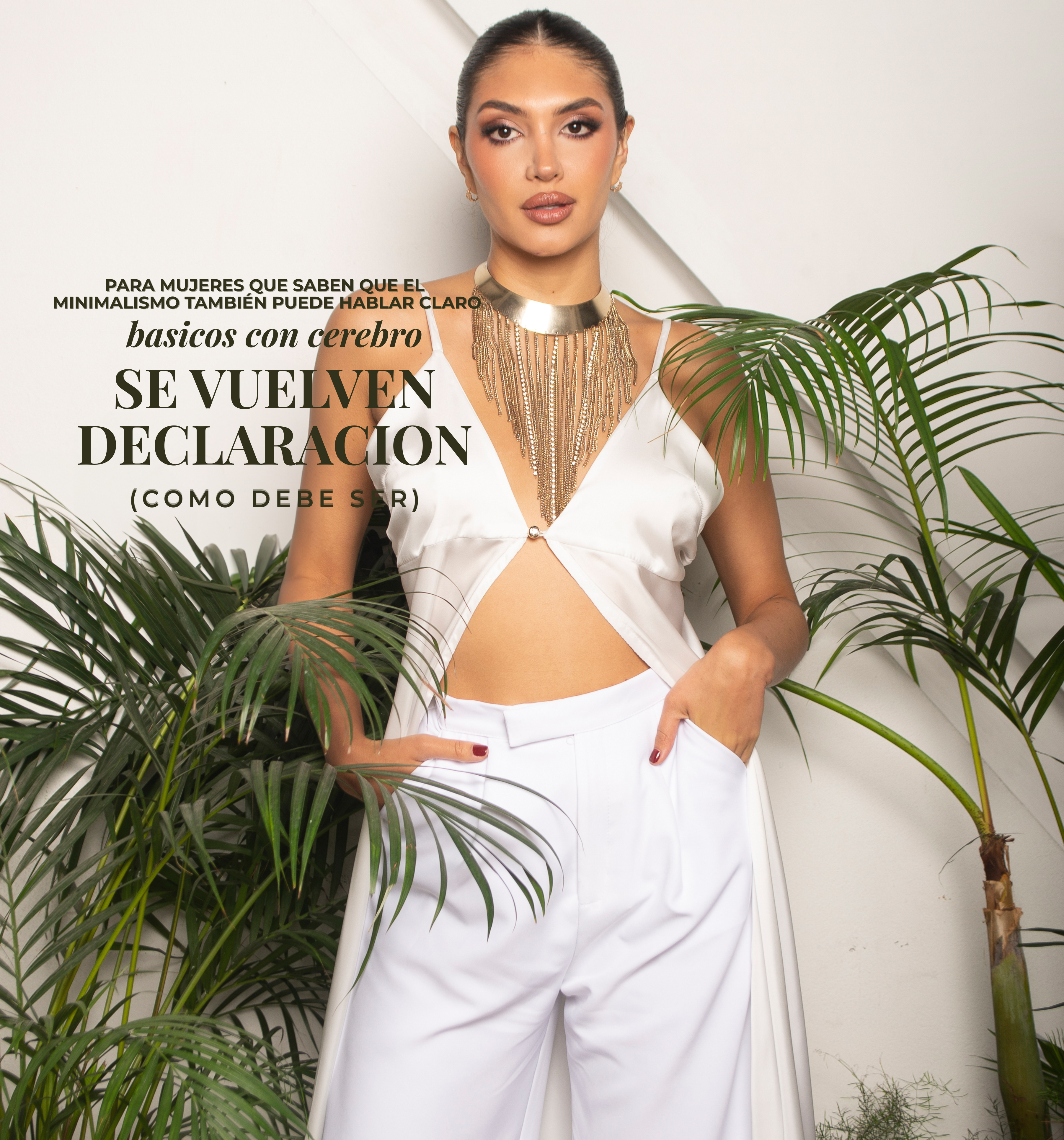 Mujer con top blanco satinado y pantalón ancho, usando collar dorado tipo statement. Look minimalista con presencia y diseño ANASTASI. Básicos con cerebro.